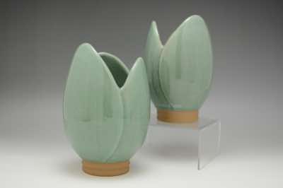 These vases were hand-thrown on a pottery wheel and hand-carved into the shape of a tulip.  Fine lines were carved vertically on the petals to create subtle texture which can only be seen up close.  They can also function as an utensil holder.