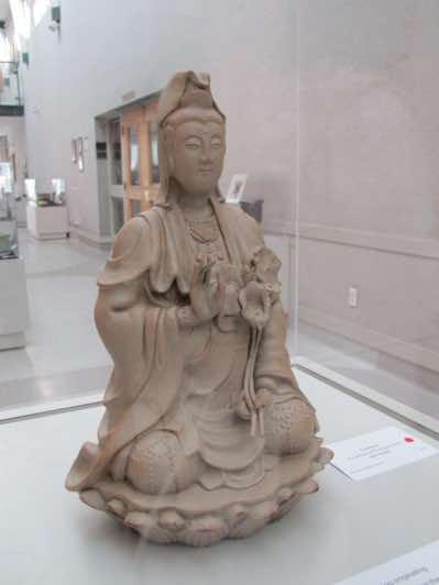 This sculpture is known as 'Guanyin', the Goddess of Compassion.  Guanyin is an enlightenment being originated from Indian buddhist legend.  The name of Guanyin means 'observing the sounds of the world'.  Guanyin in Indian buddhist legend was a male figure.  As buddhism spread to the other regions of East Asia, Guanyin became popular among female worshippers and was then transformed into a female form on which this sculpture is based.  This sculpture is 30cm in height.