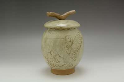This lidded jar was hand-thrown on a pottery wheel, randomly brushed on white-colored slip using hand-made straw brush and, on top of the slip, hand-carved with hummingbirds.  The branch on top of the lid was carefully hand-carved to make it look like a real branch.