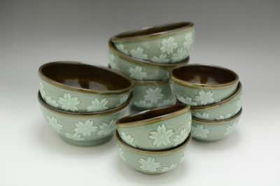 These serving bowls were hand-thrown and hand-carved with cherry blossoms.  They come in 2 sizes - small (11.5cm or 4.5inch in diameter) and medium (16cm or 6.25inch in diameter).  Because celadon is a crackle glaze, dark tenmoku glaze is used for the interior of the bowl instead.   