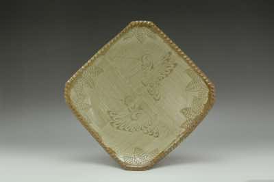 This square plate was hand-thrown on a pottery wheel and cut into shape.  The rim of the plate was pressed with finger throughout to produce such effect.  White-color slip was brushed on with hand-made straw brush before hummingbirds and leaves were carefully carved by hand.