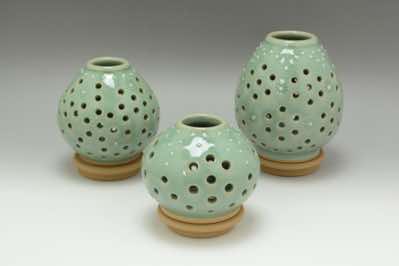 These 2-piece tealight candle holders  are easy to replace tealight candle by simply lifting up the top portion.  Holes were drilled by hand and daisy flowers were imprinted around and white-colored slip was carefully dripped onto the vessel to form white dots.   