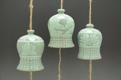 These wind chimes, inspired by the bells found in Asian temples, were hand-thrown and hand-carved with traditional Asian patterns.  The patterns include lotus flowers, peony leaves,  peonies, cherry blossoms (not shown), water lilies (not shown) and bamboo (not shown).  Each wind chime is already assembled with natural jute string (and along with it, fishing line to add strength), ceramic striker (to make sound) and wooden windcatcher (on which wishes and blessings can be written with Sharpie pen).  They can be hung outdoor on a porch or under an overhang.